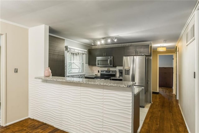 808 NE 62nd St, Gladstone, MO 64118 - kitchen featuring stainless steel appliances, a peninsula, wood finished floors, baseboards, and ornamental molding