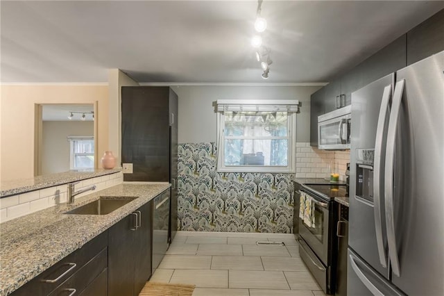 808 NE 62nd St, Gladstone, MO 64118 - kitchen with stainless steel appliances, a sink, light stone counters, baseboards, and tasteful backsplash