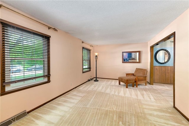 1131 Wildwood St, Leavenworth, KS 66048 - living area with light colored carpet, a textured ceiling, and baseboards