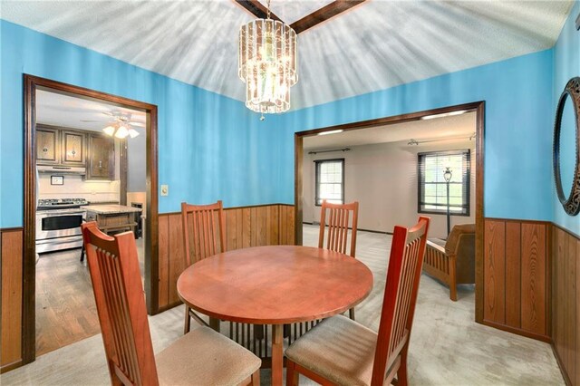1131 Wildwood St, Leavenworth, KS 66048 - dining area with a wainscoted wall, wood walls, ceiling fan, and a chandelier