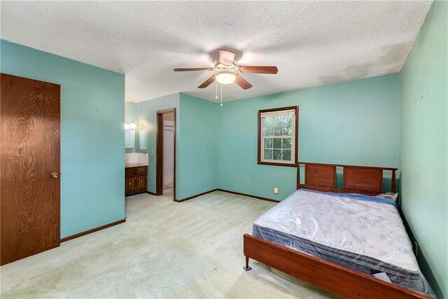 1131 Wildwood St, Leavenworth, KS 66048 - bedroom with carpet, baseboards, a textured ceiling, a ceiling fan, and connected bathroom