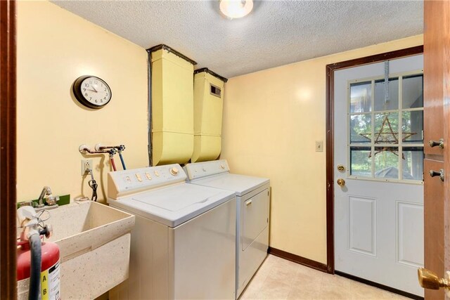 1131 Wildwood St, Leavenworth, KS 66048 - washroom featuring a textured ceiling, washing machine and clothes dryer, baseboards, and light tile patterned flooring
