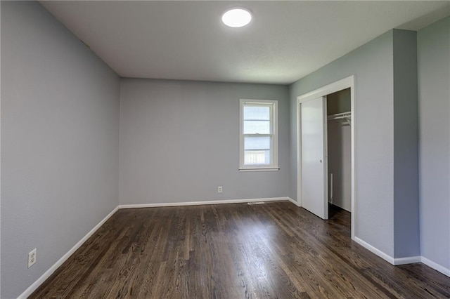 9203 James A Reed Rd, Kansas City, MO 64138 - unfurnished bedroom featuring dark wood-style flooring, baseboards, and a closet