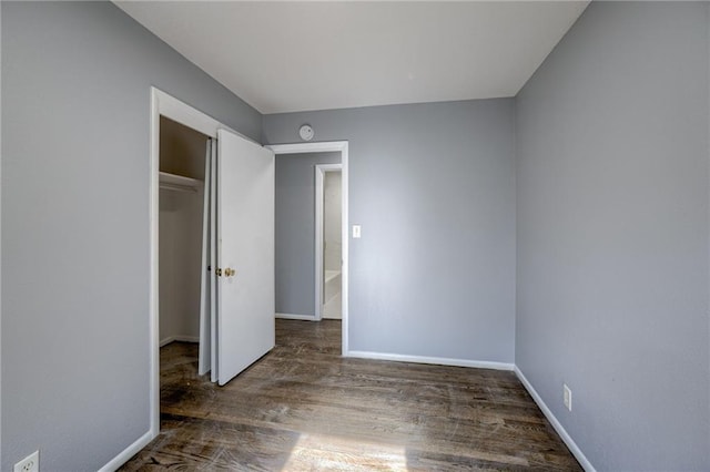 9203 James A Reed Rd, Kansas City, MO 64138 - unfurnished bedroom featuring wood finished floors, baseboards, and a closet