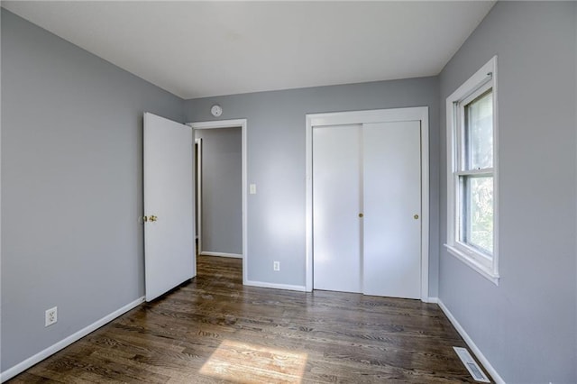 9203 James A Reed Rd, Kansas City, MO 64138 - unfurnished bedroom with wood finished floors, baseboards, and a closet