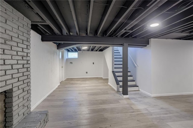 9203 James A Reed Rd, Kansas City, MO 64138 - below grade area featuring stairs, wood finished floors, and baseboards