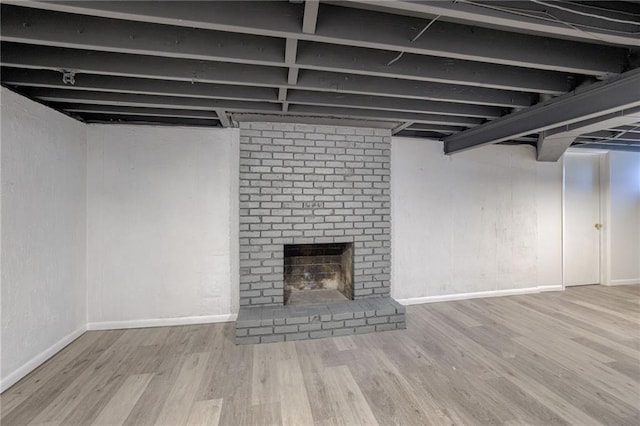 9203 James A Reed Rd, Kansas City, MO 64138 - finished below grade area with wood finished floors, baseboards, and a fireplace