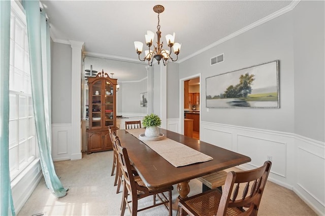 11580 S Skyview Ln, Olathe, KS 66061 - dining area featuring a chandelier, a decorative wall, wainscoting, light colored carpet, and crown molding