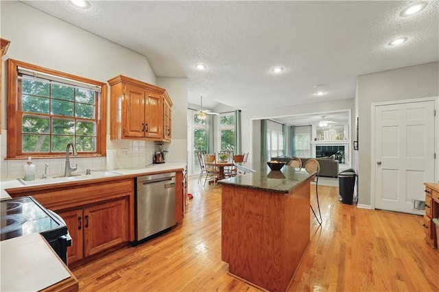 11580 S Skyview Ln, Olathe, KS 66061 - kitchen featuring stainless steel dishwasher, ceiling fan, a textured ceiling, decorative backsplash, and a kitchen island