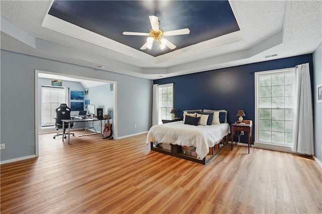 11580 S Skyview Ln, Olathe, KS 66061 - bedroom featuring a tray ceiling, a desk, wood finished floors, baseboards, and a ceiling fan