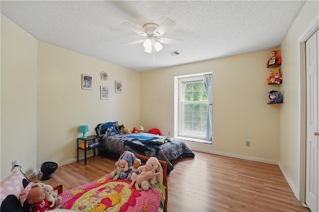 11580 S Skyview Ln, Olathe, KS 66061 - bedroom featuring wood finished floors, a textured ceiling, ceiling fan, and baseboards