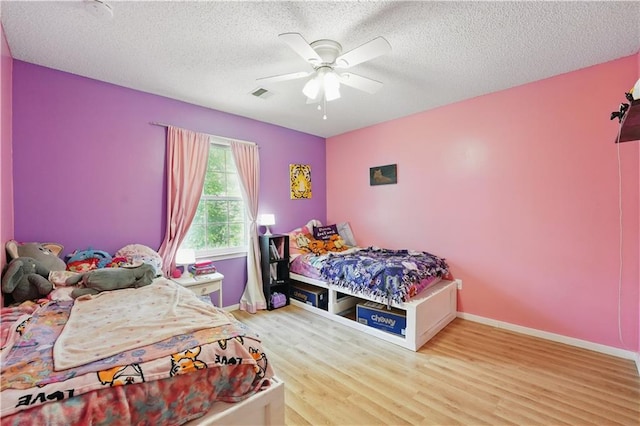 11580 S Skyview Ln, Olathe, KS 66061 - bedroom featuring wood finished floors, ceiling fan, a textured ceiling, and baseboards