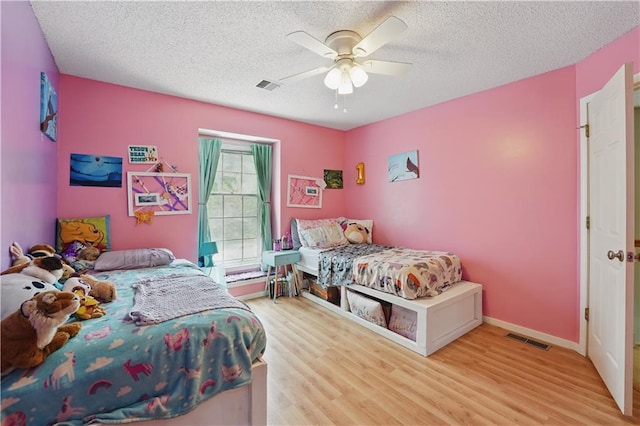 11580 S Skyview Ln, Olathe, KS 66061 - bedroom featuring wood finished floors, a textured ceiling, ceiling fan, and baseboards