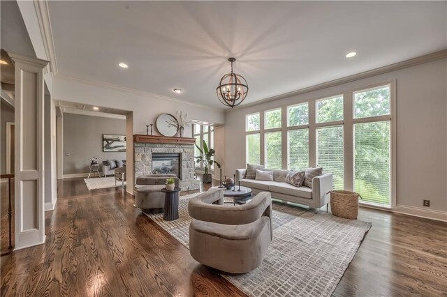 14606 Granada Rd, Leawood, KS 66224 - living area featuring crown molding, baseboards, a stone fireplace, dark wood finished floors, and a chandelier