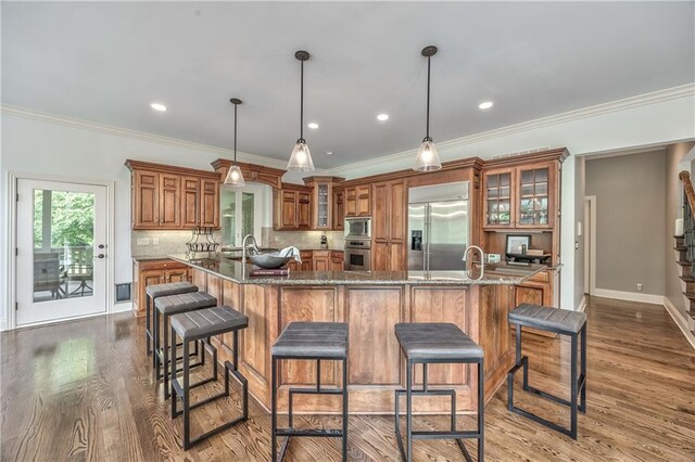 14606 Granada Rd, Leawood, KS 66224 - kitchen featuring built in appliances, brown cabinets, a large island, tasteful backsplash, and a sink