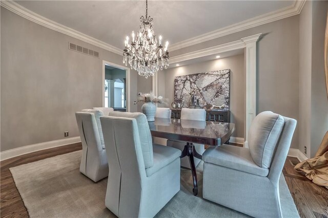 14606 Granada Rd, Leawood, KS 66224 - dining area featuring a chandelier, wood finished floors, crown molding, and baseboards