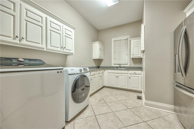 14606 Granada Rd, Leawood, KS 66224 - laundry room featuring cabinet space, washing machine and clothes dryer, light tile patterned floors, and baseboards