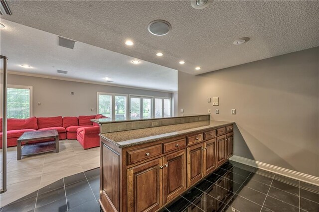 14606 Granada Rd, Leawood, KS 66224 - kitchen with a textured ceiling, plenty of natural light, a peninsula, baseboards, and brown cabinets