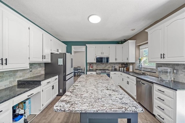 12890 S Greenwood St, Olathe, KS 66062 - kitchen featuring stainless steel appliances, a sink, a textured ceiling, and tasteful backsplash