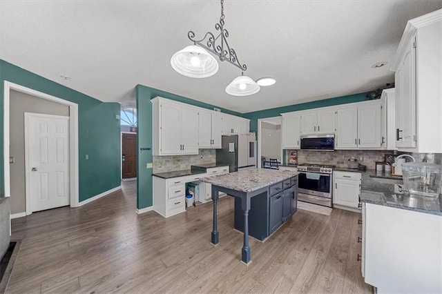 12890 S Greenwood St, Olathe, KS 66062 - kitchen featuring appliances with stainless steel finishes, tasteful backsplash, white cabinets, and a textured ceiling
