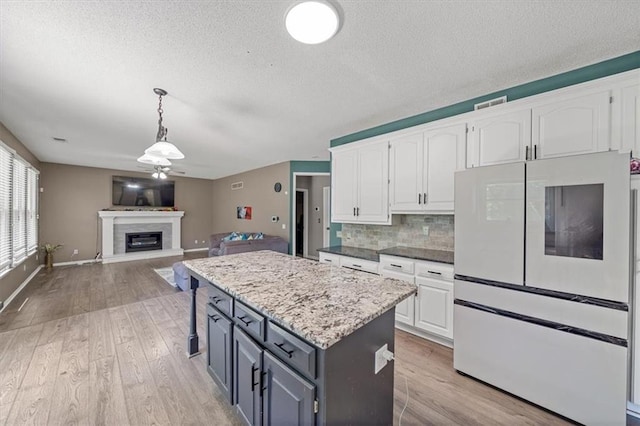 12890 S Greenwood St, Olathe, KS 66062 - kitchen featuring freestanding refrigerator, white cabinets, a ceiling fan, and a textured ceiling