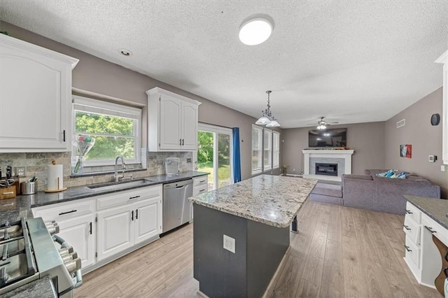 12890 S Greenwood St, Olathe, KS 66062 - kitchen with stainless steel appliances, a textured ceiling, light wood-style floors, a sink, and tasteful backsplash