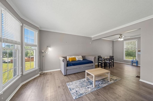12890 S Greenwood St, Olathe, KS 66062 - living room featuring a textured ceiling, ornamental molding, plenty of natural light, wood finished floors, and baseboards