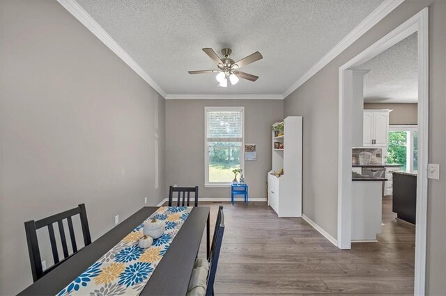 12890 S Greenwood St, Olathe, KS 66062 - dining room with ceiling fan, a textured ceiling, wood finished floors, crown molding, and baseboards