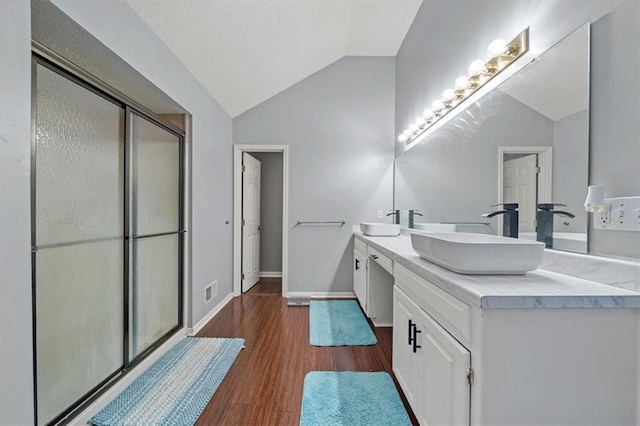 12890 S Greenwood St, Olathe, KS 66062 - full bathroom with vaulted ceiling, double vanity, a shower stall, wood finished floors, and baseboards