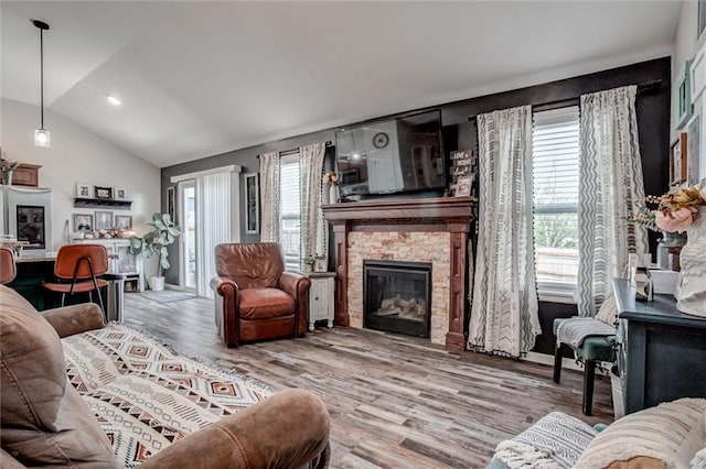 1609 Bluestem Dr, Ottawa, KS 66067 - living room with lofted ceiling, a stone fireplace, and wood finished floors