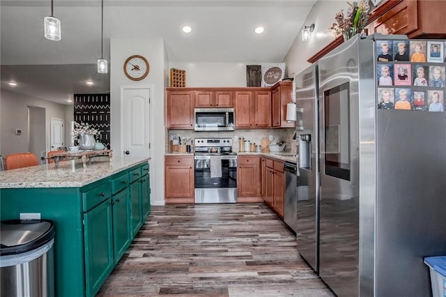 1609 Bluestem Dr, Ottawa, KS 66067 - kitchen with stainless steel appliances, dark wood-style floors, a kitchen island, decorative light fixtures, and backsplash
