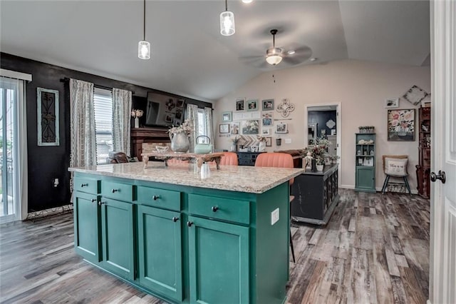 1609 Bluestem Dr, Ottawa, KS 66067 - kitchen featuring green cabinets, light wood-style floors, lofted ceiling, a ceiling fan, and a kitchen island