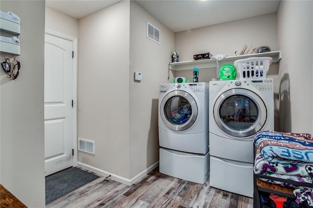 1609 Bluestem Dr, Ottawa, KS 66067 - laundry room with separate washer and dryer, wood finished floors, and baseboards