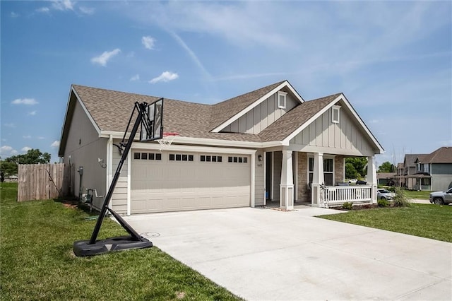 1609 Bluestem Dr, Ottawa, KS 66067 - view of front facade featuring covered porch, an attached garage, board and batten siding, a shingled roof, and driveway