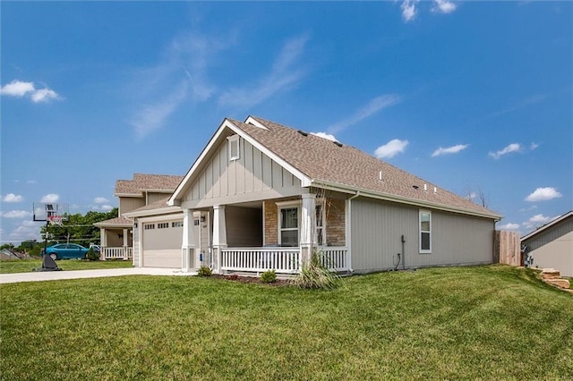 1609 Bluestem Dr, Ottawa, KS 66067 - view of front of house featuring covered porch, concrete driveway, an attached garage, stone siding, and a front lawn