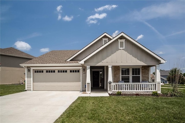 1609 Bluestem Dr, Ottawa, KS 66067 - view of front of property with board and batten siding, an attached garage, covered porch, concrete driveway, and a front lawn