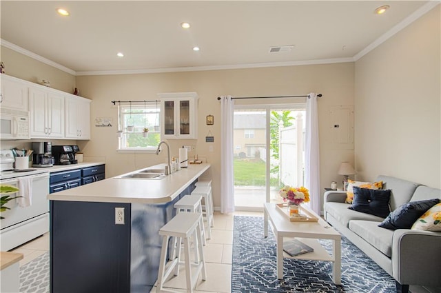 217 N 6th Ter, Louisburg, KS 66053 - kitchen with a sink, white appliances, a kitchen breakfast bar, light tile patterned flooring, and plenty of natural light