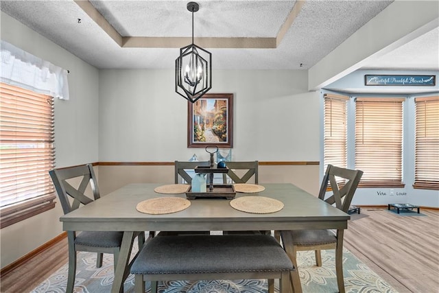 1805 N Lazy Branch Rd, Independence, MO 64058 - dining room with a chandelier, baseboards, wood finished floors, a tray ceiling, and a textured ceiling
