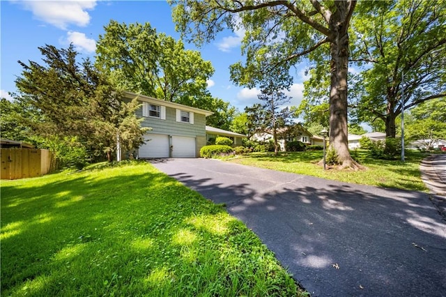 1107 E 110th St, Kansas City, MO 64131 - view of front of property with an attached garage, driveway, and a front lawn