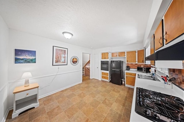 1107 E 110th St, Kansas City, MO 64131 - kitchen with black appliances, a sink, light countertops, brown cabinets, and a textured ceiling