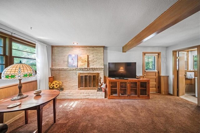 1107 E 110th St, Kansas City, MO 64131 - carpeted living area with a textured ceiling, a fireplace, and beamed ceiling