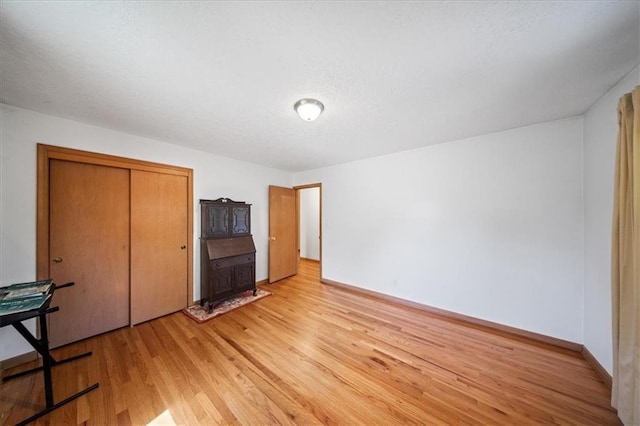 1107 E 110th St, Kansas City, MO 64131 - unfurnished bedroom featuring light wood-style flooring, a closet, and baseboards