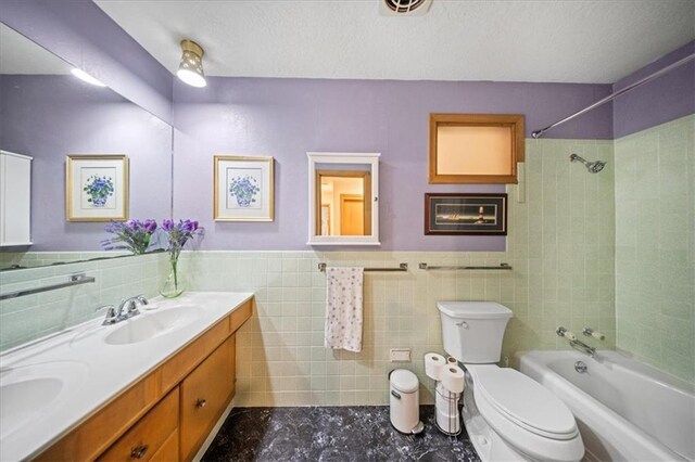 1107 E 110th St, Kansas City, MO 64131 - full bathroom featuring tile walls, toilet, bathtub / shower combination, double vanity, and a wainscoted wall