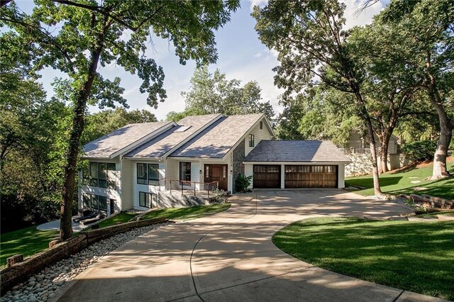 12204 Catalina St, Leawood, KS 66209 - view of front facade featuring concrete driveway, an attached garage, and a front lawn