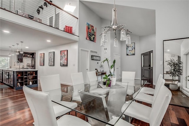12204 Catalina St, Leawood, KS 66209 - dining area featuring a towering ceiling, dark wood-style flooring, a chandelier, and recessed lighting