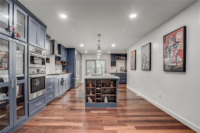 12204 Catalina St, Leawood, KS 66209 - kitchen with open shelves, light countertops, wall chimney range hood, recessed lighting, and wood finished floors
