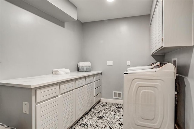 12204 Catalina St, Leawood, KS 66209 - washroom with cabinet space, washer and dryer, and light tile patterned flooring