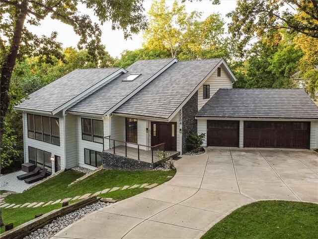 12204 Catalina St, Leawood, KS 66209 - view of front of house featuring a front lawn, an attached garage, and concrete driveway