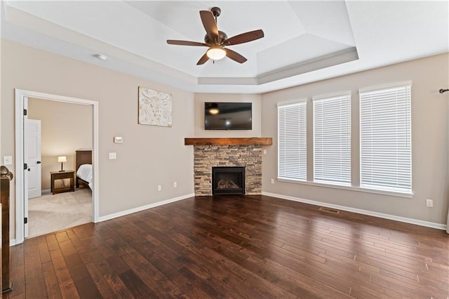 20740 W 224th St, Spring Hill, KS 66083 - unfurnished living room with a tray ceiling, dark wood-type flooring, ceiling fan, and a fireplace