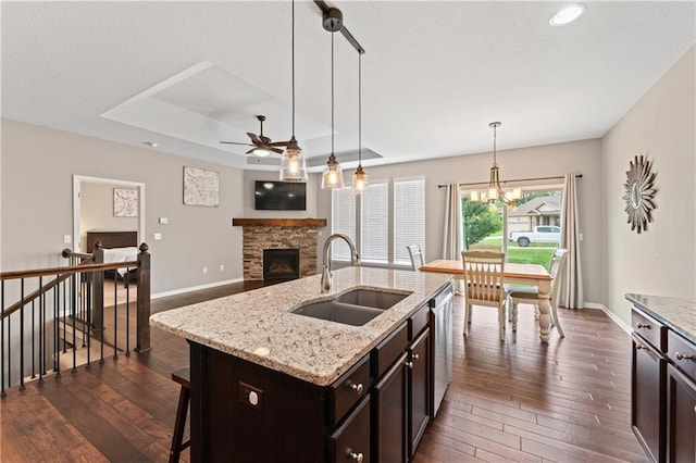 20740 W 224th St, Spring Hill, KS 66083 - kitchen with dark wood-style floors, ceiling fan, stainless steel dishwasher, a stone fireplace, and hanging light fixtures